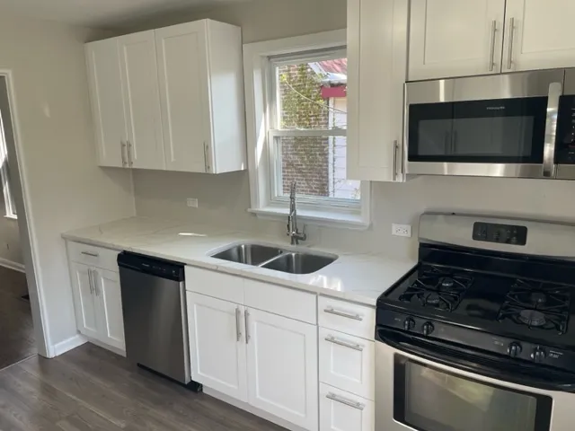 a kitchen with stainless steel appliances a sink dishwasher stove microwave and cabinets
