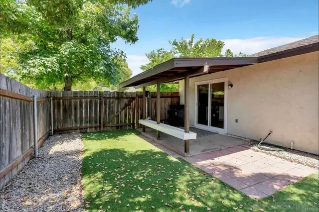 a view of a backyard with table and chairs and a large tree