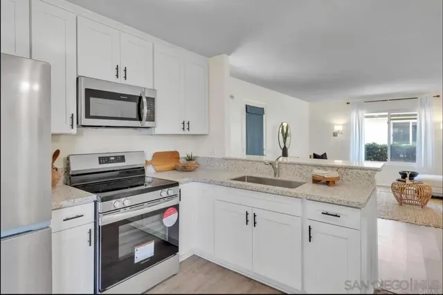 a kitchen with white cabinets and appliances