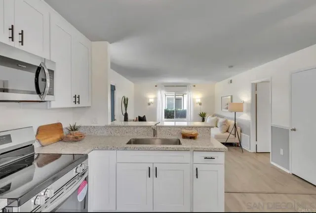 a kitchen with stainless steel appliances granite countertop a sink stove and cabinets