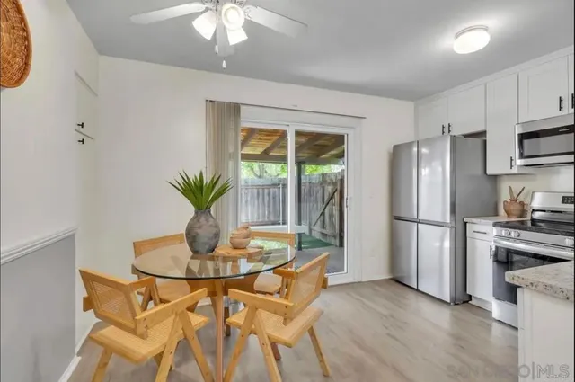 a kitchen with stainless steel appliances granite countertop a stove a refrigerator and a dining table with wooden floor