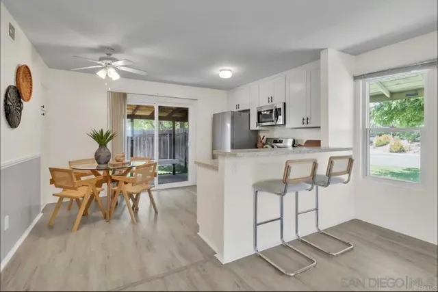 a living room with furniture a dining table and a window