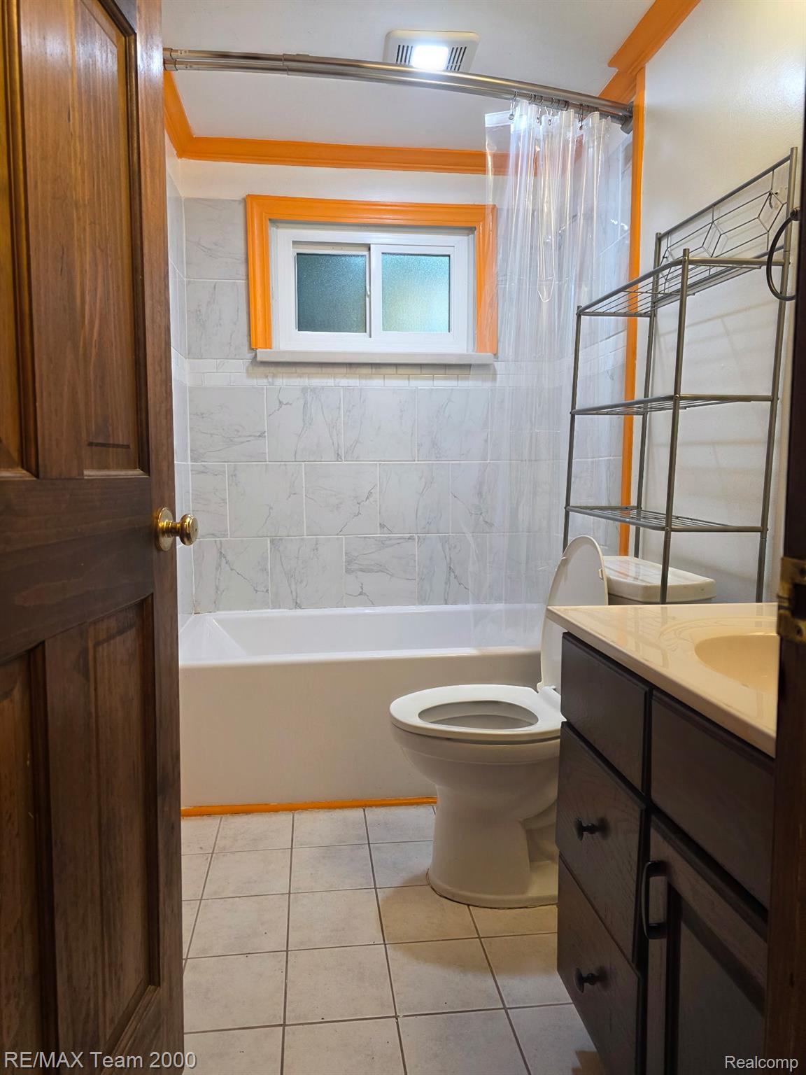38114 Walnut Street Romulus, MI 48174 - Photo 7 of 18 Bathroom featuring a white bathtub, ceramic tile flooring, and a vanity with a light-colored countertop