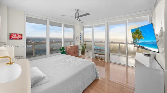 a spacious bedroom with a balcony a bed and a double vanity sink