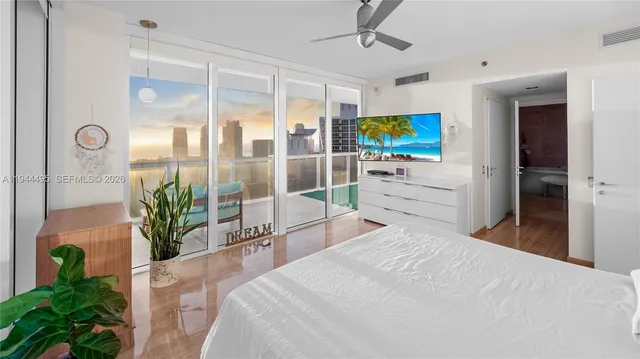 a bedroom with a large bed and a flat screen tv