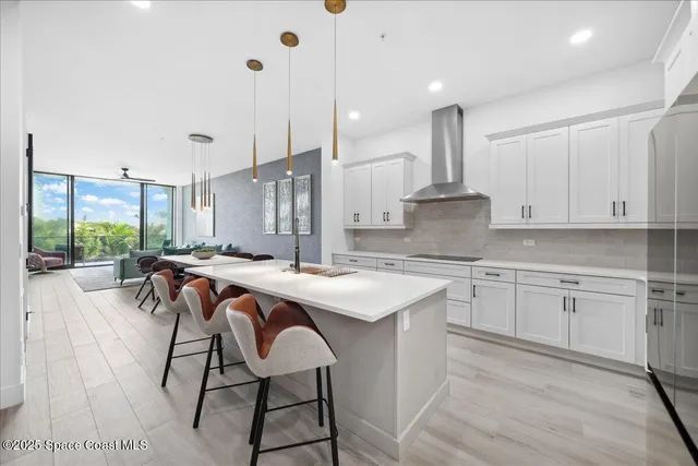 a living room with furniture a large window and wooden floor