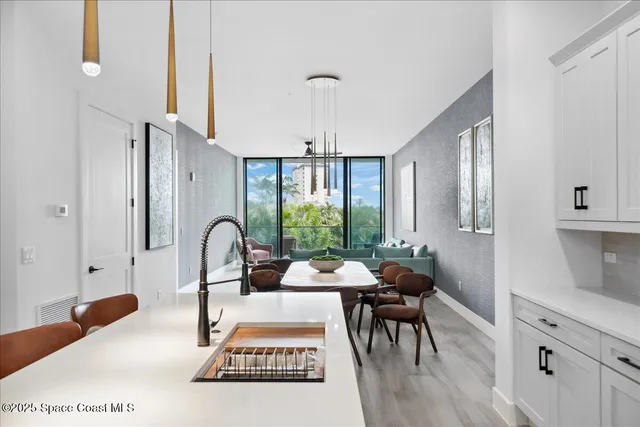 a kitchen with a stove a sink a kitchen island with wooden cabinets and wooden floor