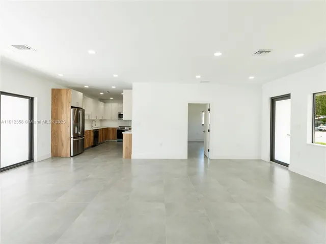 a view of an empty room with closet and a window