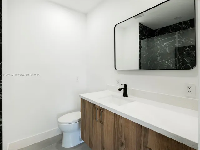 a bathroom with a sink a toilet and mirror
