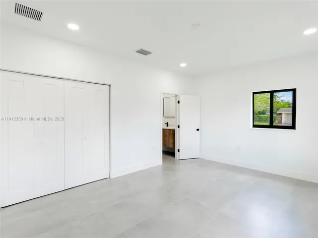 an empty room with closet and a hallway