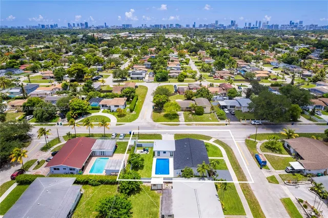 an aerial view of residential houses with outdoor space and swimming pool