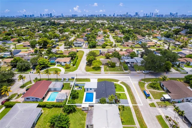 an aerial view of residential houses with outdoor space and street view