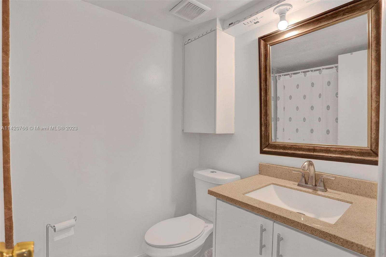 3410 Foxcroft Road, Unit 202 Miramar, FL 33025 - Photo 12 of 35 a bathroom with a granite countertop sink mirror vanity and toilet