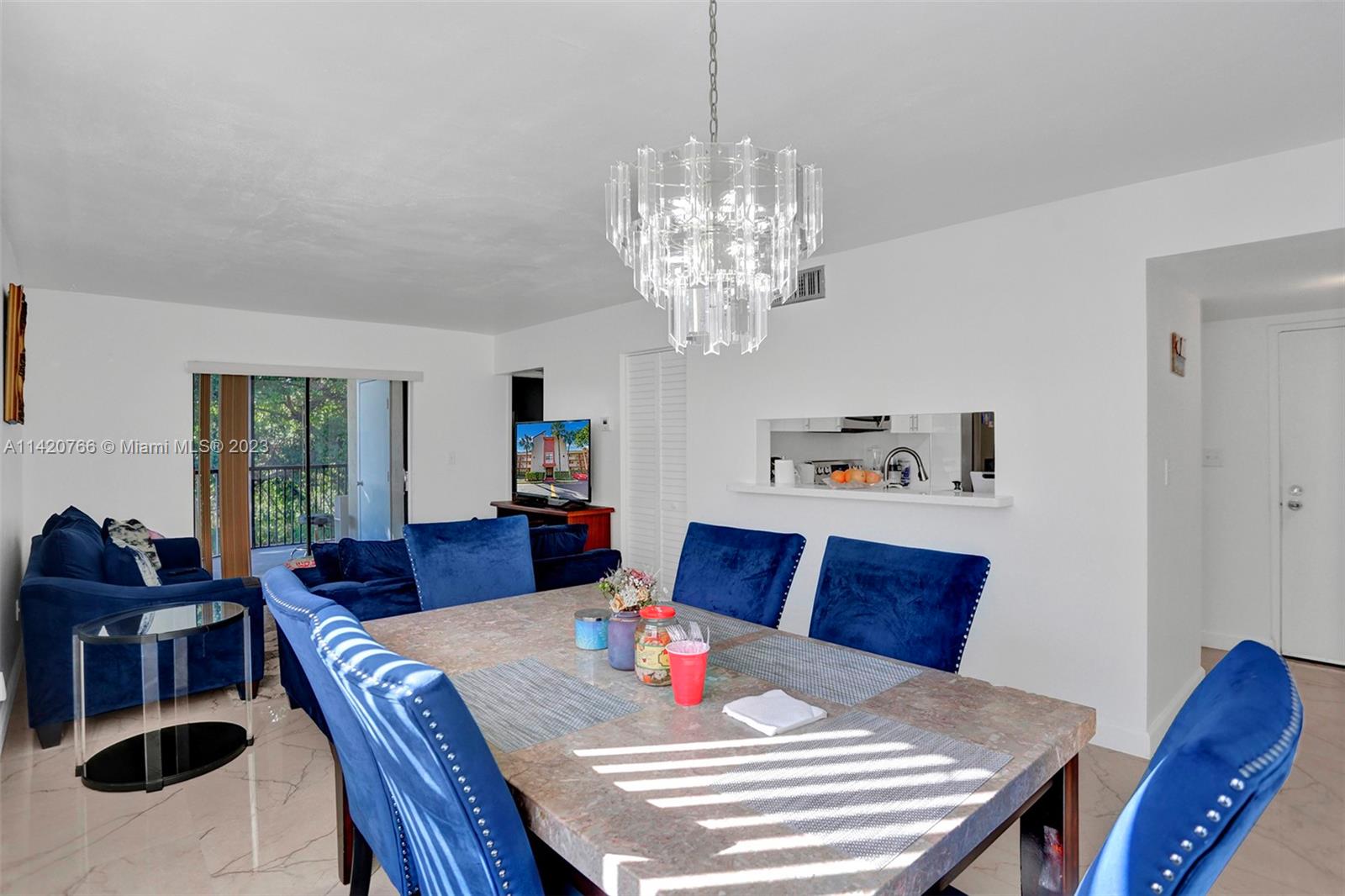 3410 Foxcroft Road, Unit 202 Miramar, FL 33025 - Photo 21 of 35 a view of a dining room with furniture a chandelier and wooden floor