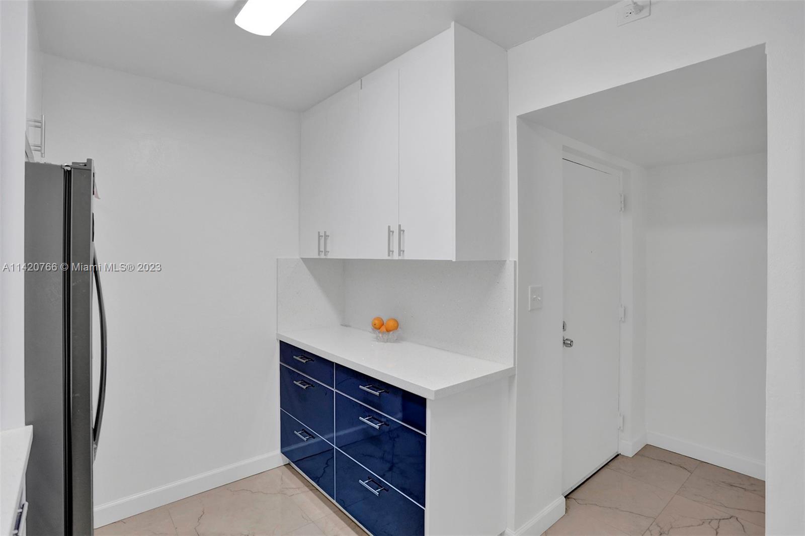 3410 Foxcroft Road, Unit 202 Miramar, FL 33025 - Photo 3 of 35 a kitchen with cabinets and a refrigerator