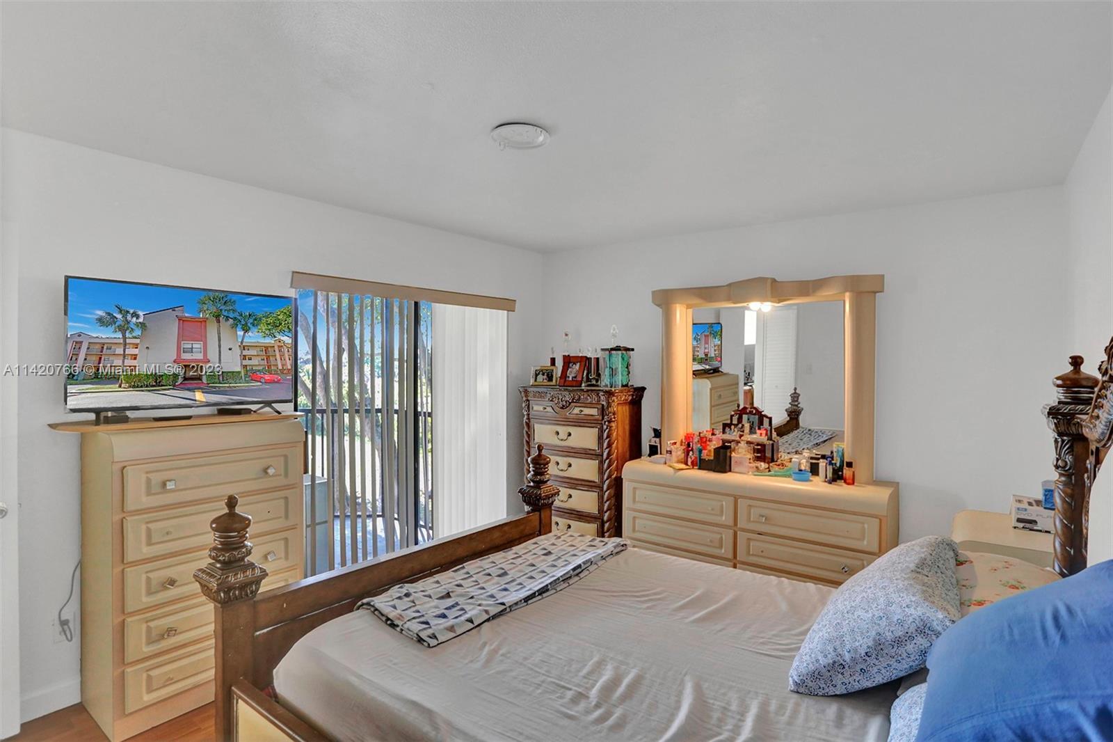 3410 Foxcroft Road, Unit 202 Miramar, FL 33025 - Photo 9 of 35 a bedroom with furniture and a book shelf