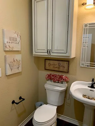 a bathroom with a sink a toilet and a mirror