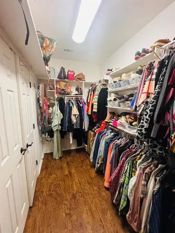 a view of walk in closet with clothes