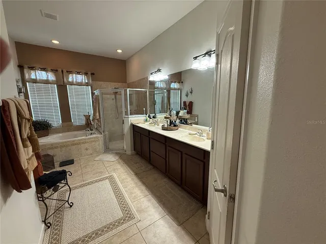 a bathroom with sink a mirror a vanity and a shower