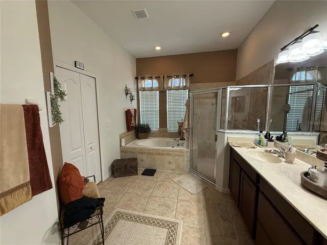 a bedroom with a bed painting on wall and a large mirror