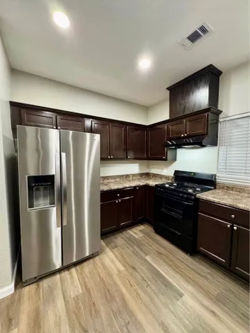 a kitchen with stainless steel appliances granite countertop a refrigerator and a stove