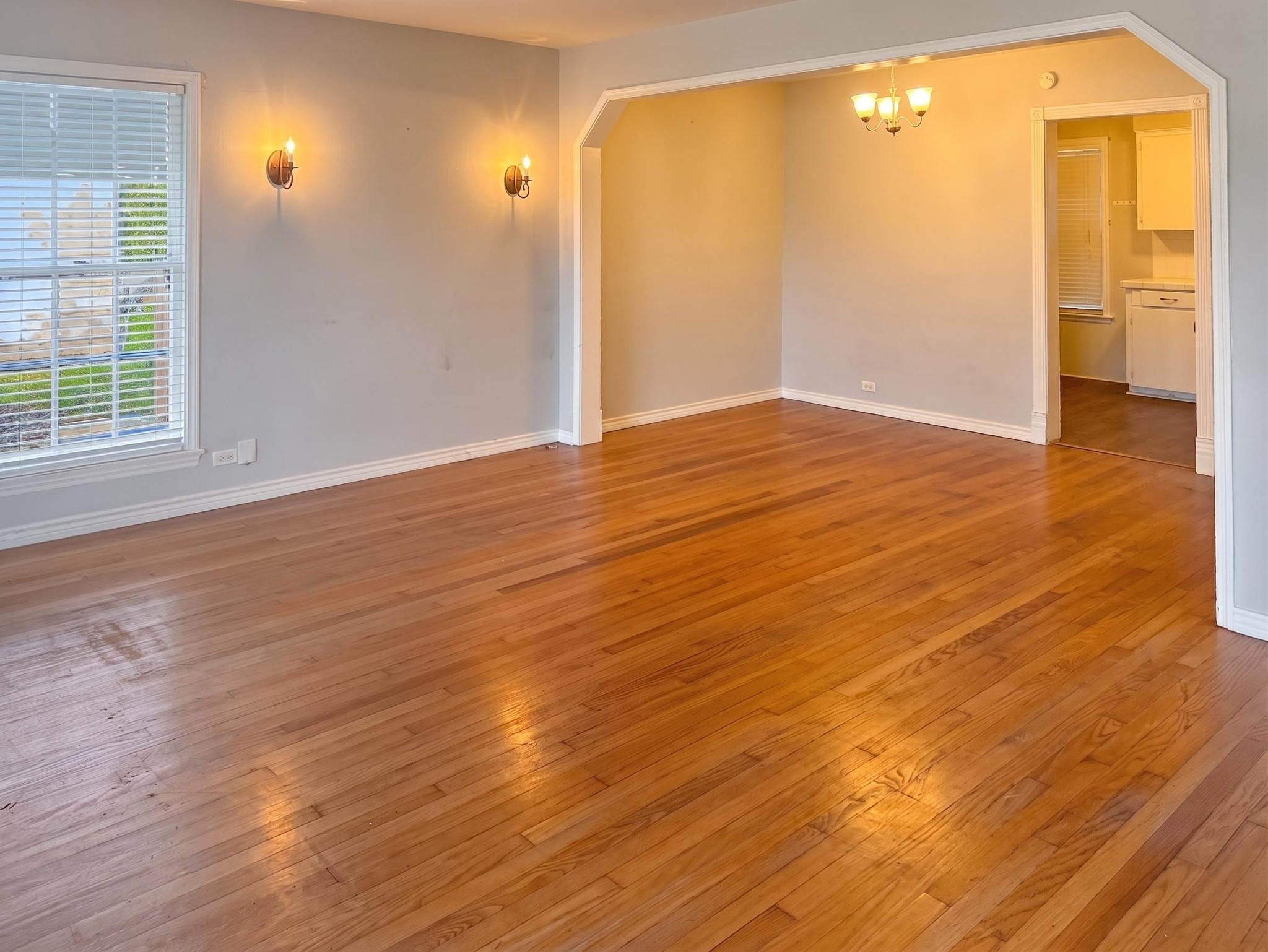 2313 Avenue L Rosenberg, TX 77471 - Photo 8 of 31 Alternate view of the expansive living and dining areas showcasing the open flow and timeless hardwood floors.