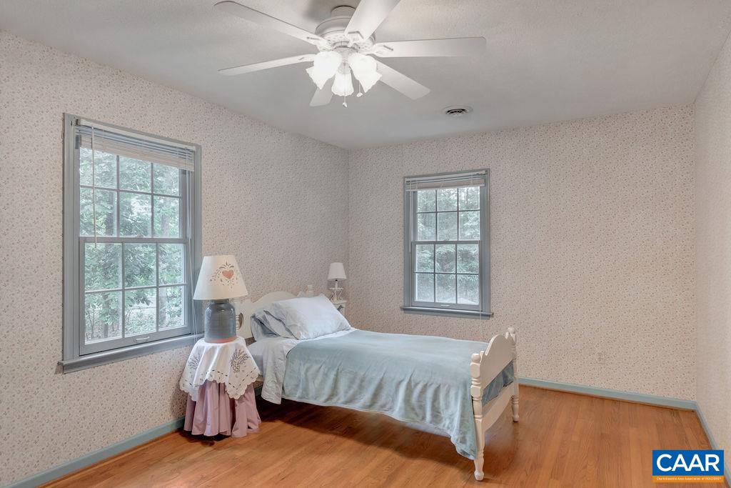 4875 Mechunk Road Keswick, VA 22947 - Photo 19 of 38 a bedroom with a bed chandelier and a window