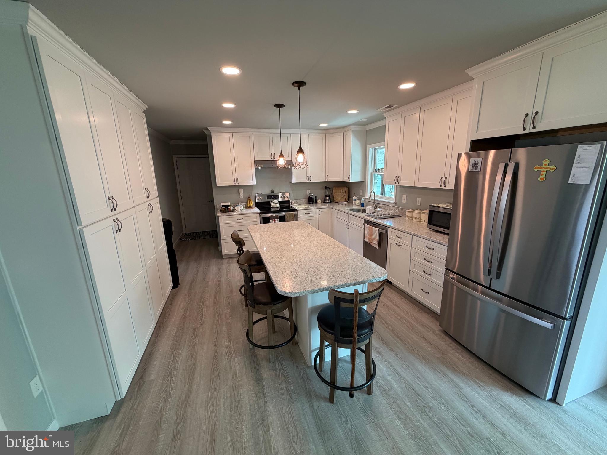 36032 Double Bridges Road Frankford, DE 19945 - Photo 22 of 51 a kitchen with stainless steel appliances a refrigerator a stove a sink a dining table and chairs