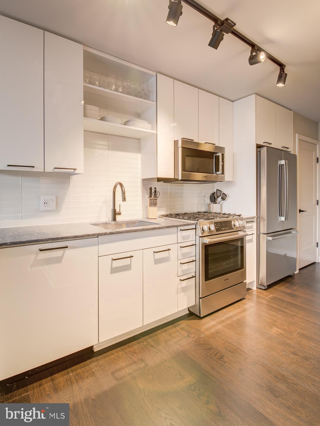 a kitchen with cabinets a sink and steel appliances