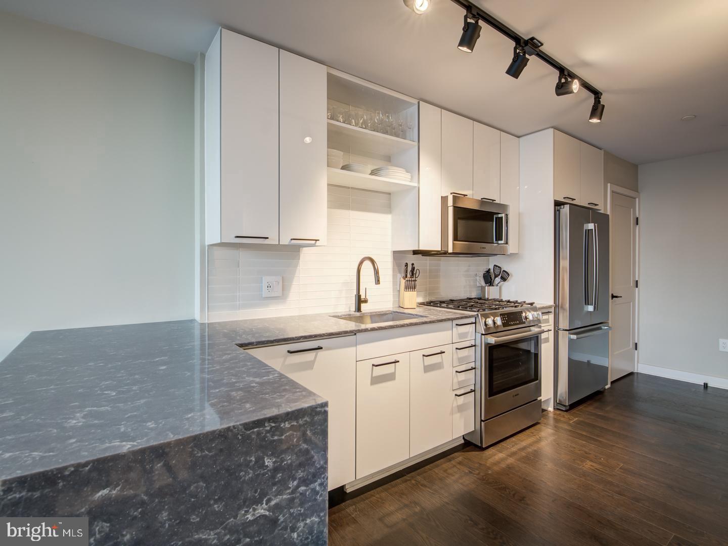 70 N Street Southeast, Unit N607 Washington, DC 20003 - Photo 4 of 20 a kitchen with stainless steel appliances granite countertop a sink stove and refrigerator