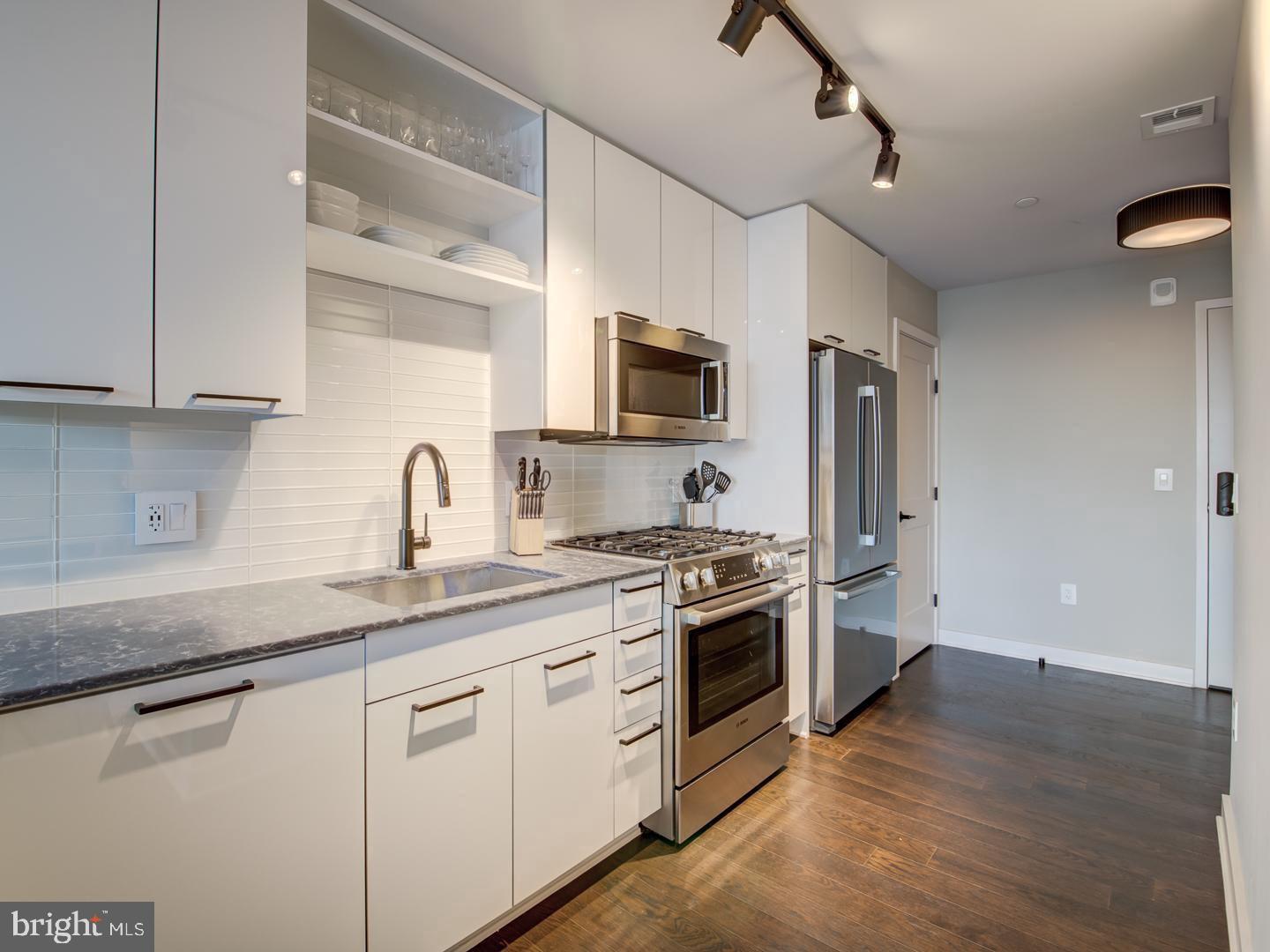 70 N Street Southeast, Unit N607 Washington, DC 20003 - Photo 5 of 20 a kitchen with stainless steel appliances granite countertop a sink a stove a refrigerator and cabinets