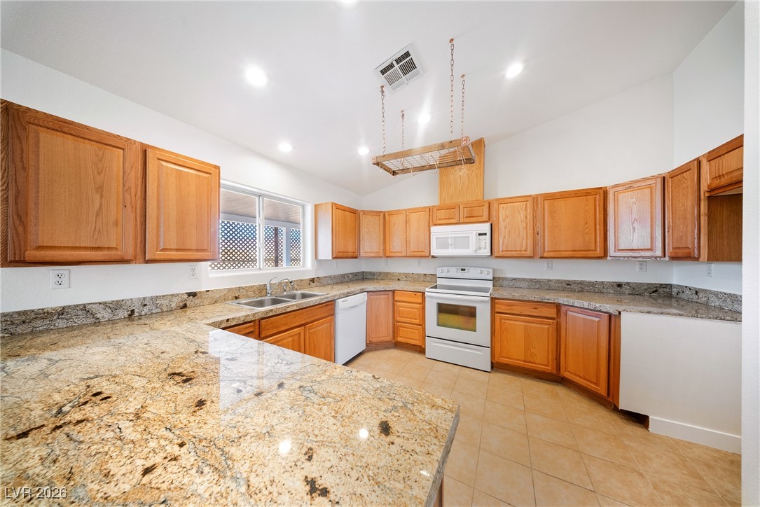2420 Tough Boy Road Pahrump, NV 89060 - Photo 13 of 54 Kitchen with white appliances, high vaulted ceiling, light tile patterned floors, light stone countertops, and recessed lighting