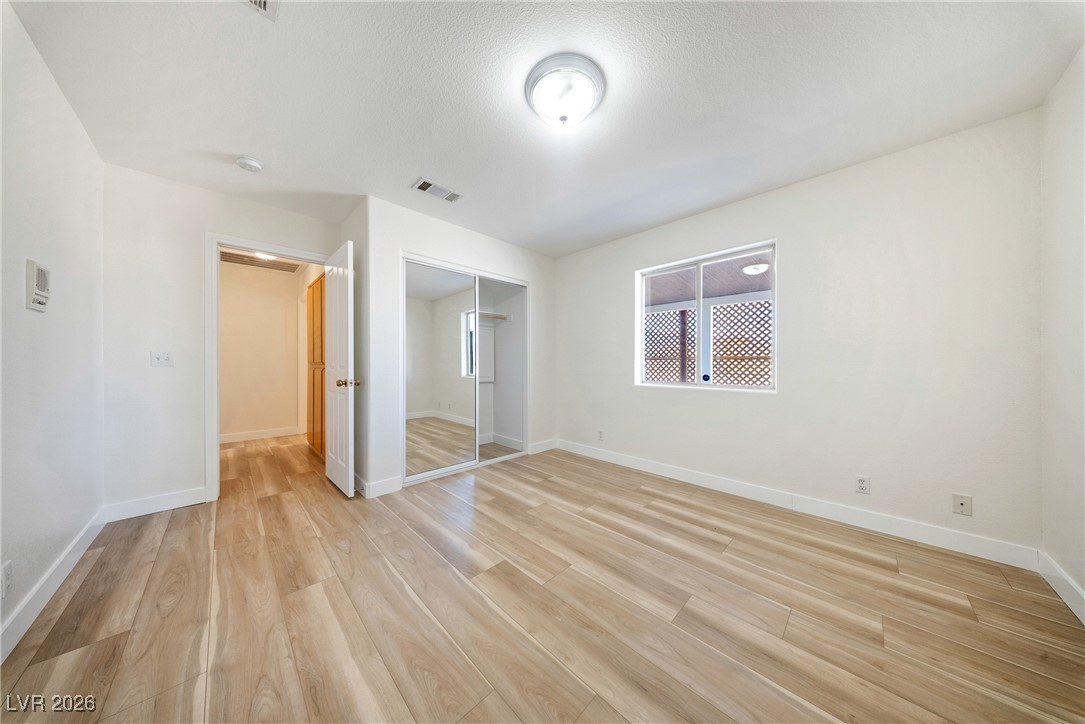 2420 Tough Boy Road Pahrump, NV 89060 - Photo 24 of 54 Unfurnished bedroom with light wood finished floors and a closet