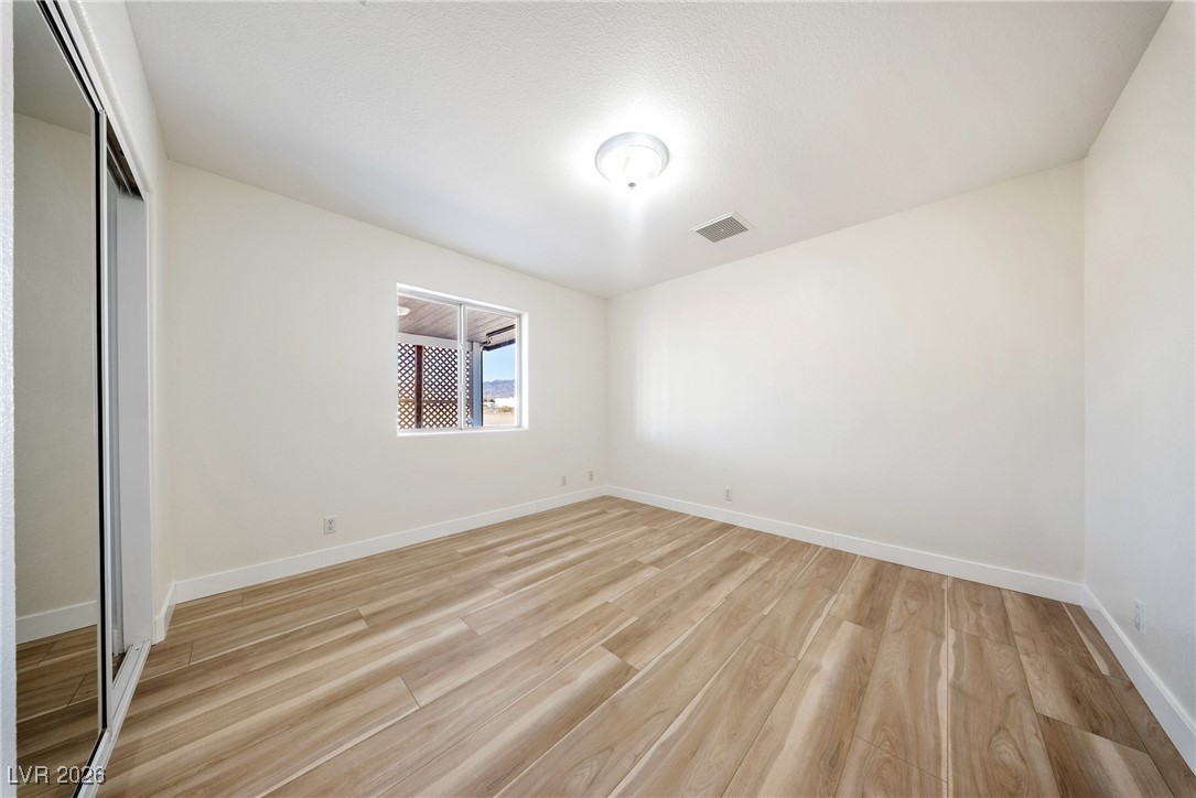 2420 Tough Boy Road Pahrump, NV 89060 - Photo 26 of 54 Unfurnished bedroom featuring a closet and light wood-style flooring