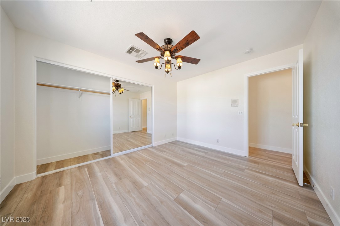 2420 Tough Boy Road Pahrump, NV 89060 - Photo 29 of 54 Unfurnished bedroom featuring light wood finished floors, a ceiling fan, and a closet