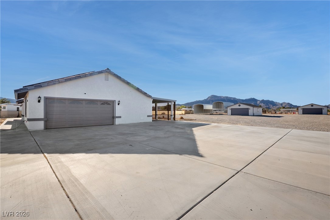 2420 Tough Boy Road Pahrump, NV 89060 - Photo 33 of 54 View of home's exterior featuring a mountain view, driveway, and stucco siding
