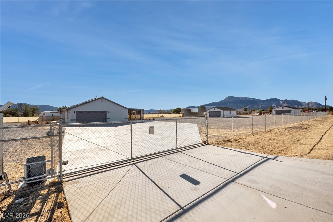 2420 Tough Boy Road Pahrump, NV 89060 - Photo 37 of 54 View of yard featuring a gate, a mountain view, and a garage