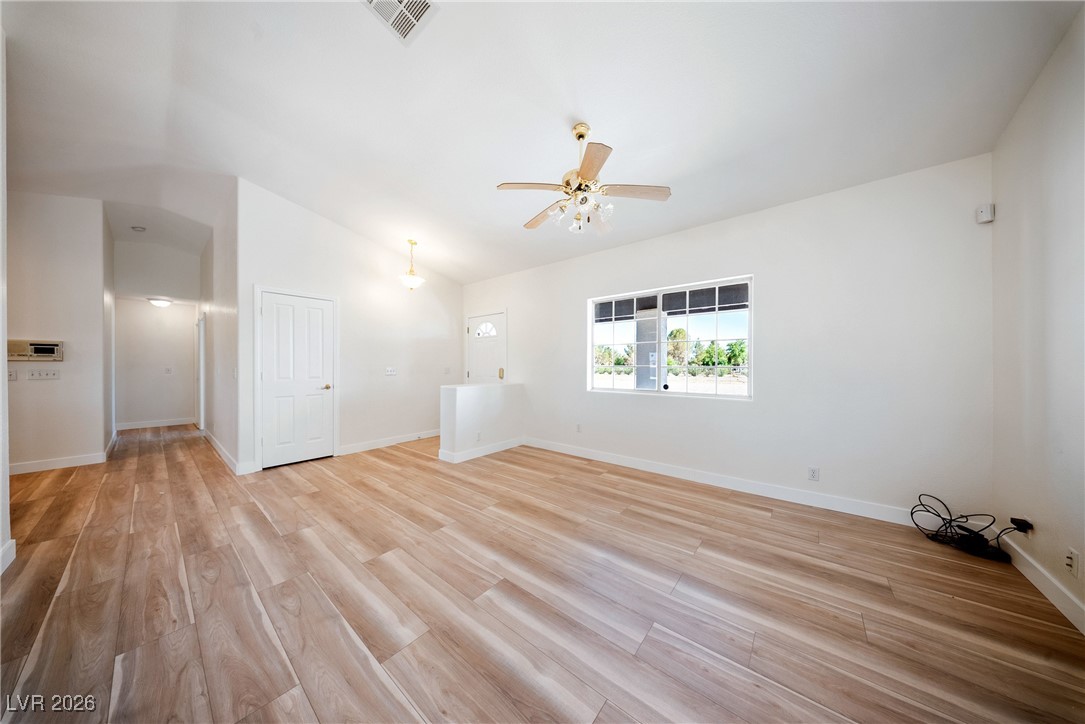 2420 Tough Boy Road Pahrump, NV 89060 - Photo 5 of 54 Empty room featuring a ceiling fan, light wood finished floors, and lofted ceiling