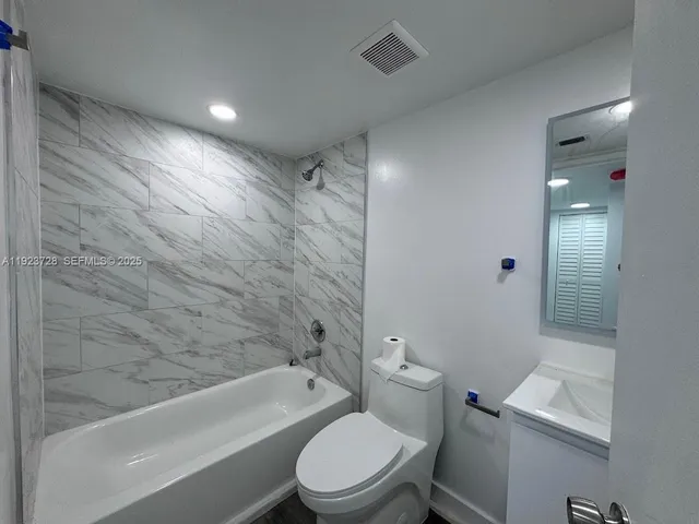 a bathroom with a toilet a sink and bathtub