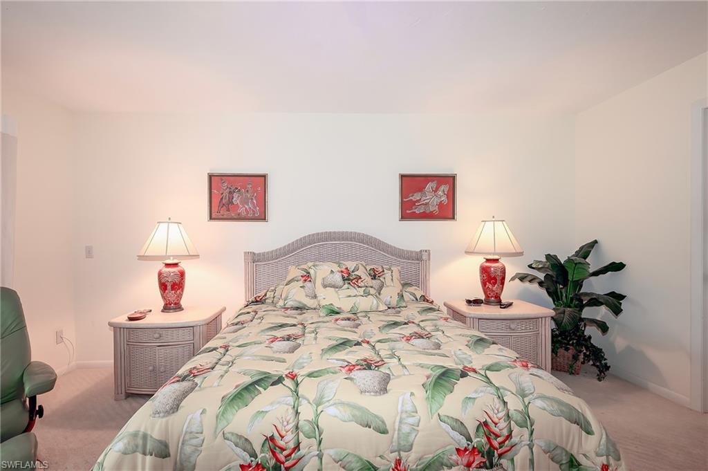 1100 9th Street South, Unit E101 Naples, FL 34102 - Photo 12 of 35 a bedroom with a bed and a potted plant