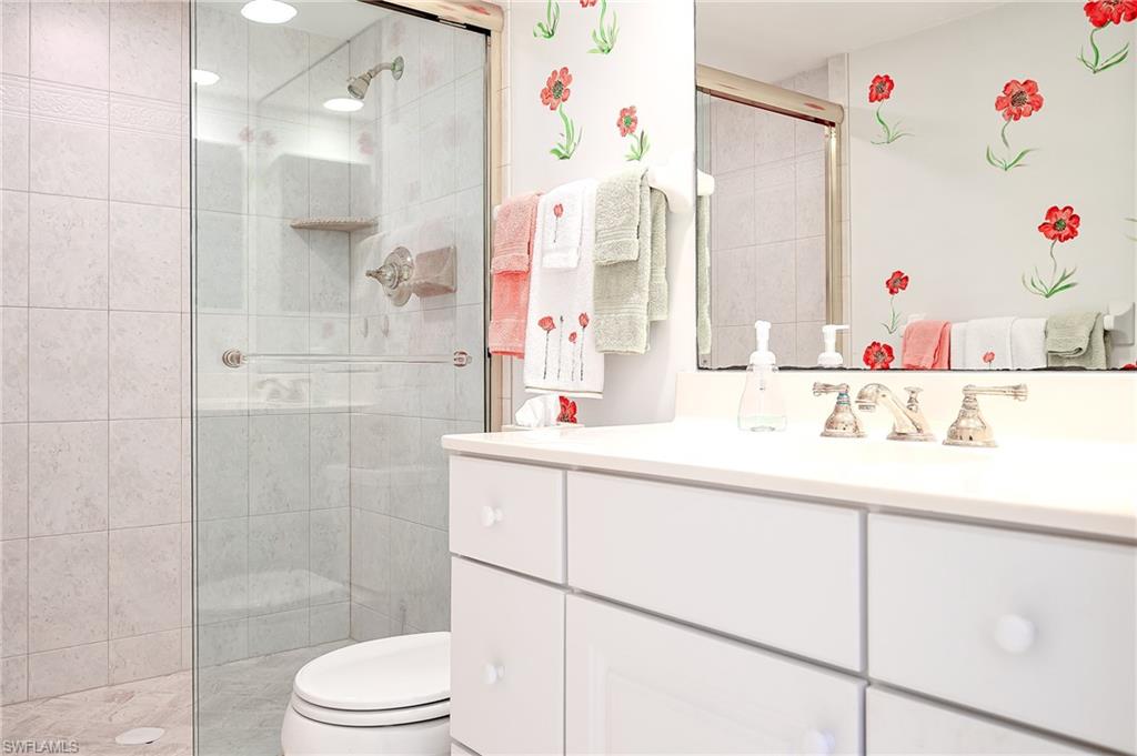 1100 9th Street South, Unit E101 Naples, FL 34102 - Photo 16 of 35 a bathroom with a sink vanity mirror and shower