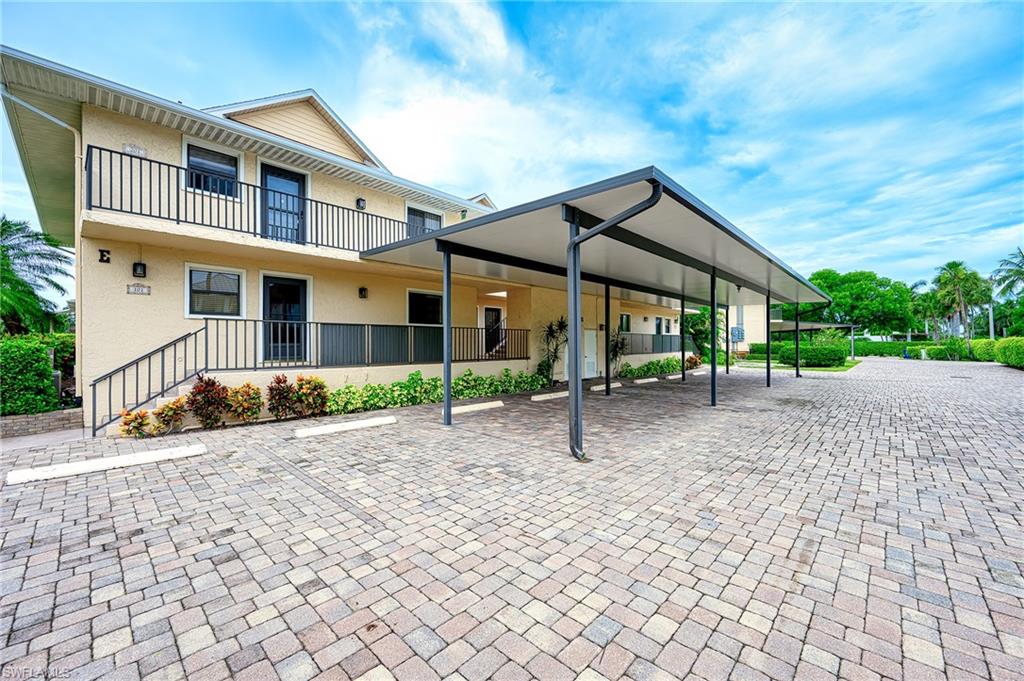 1100 9th Street South, Unit E101 Naples, FL 34102 - Photo 2 of 35 a house view with a garden space