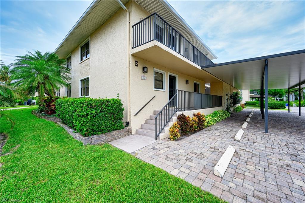 1100 9th Street South, Unit E101 Naples, FL 34102 - Photo 3 of 35 a front view of a house with garden