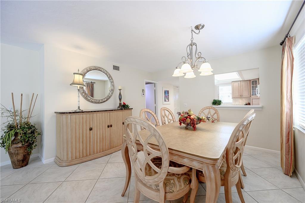 1100 9th Street South, Unit E101 Naples, FL 34102 - Photo 6 of 35 a view of a dining room with furniture and a chandelier