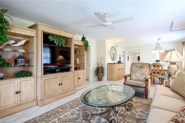 a living room with furniture a flat screen tv and a rug