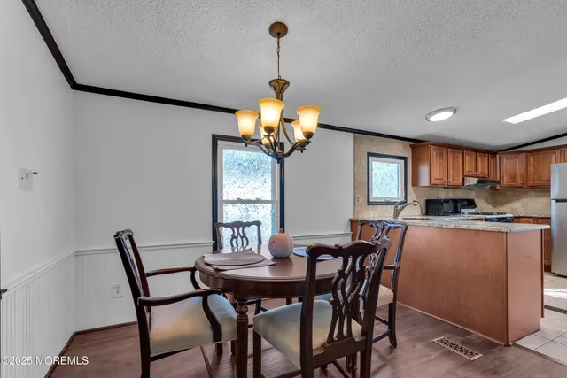 a dining room filled chandelier and wooden floor