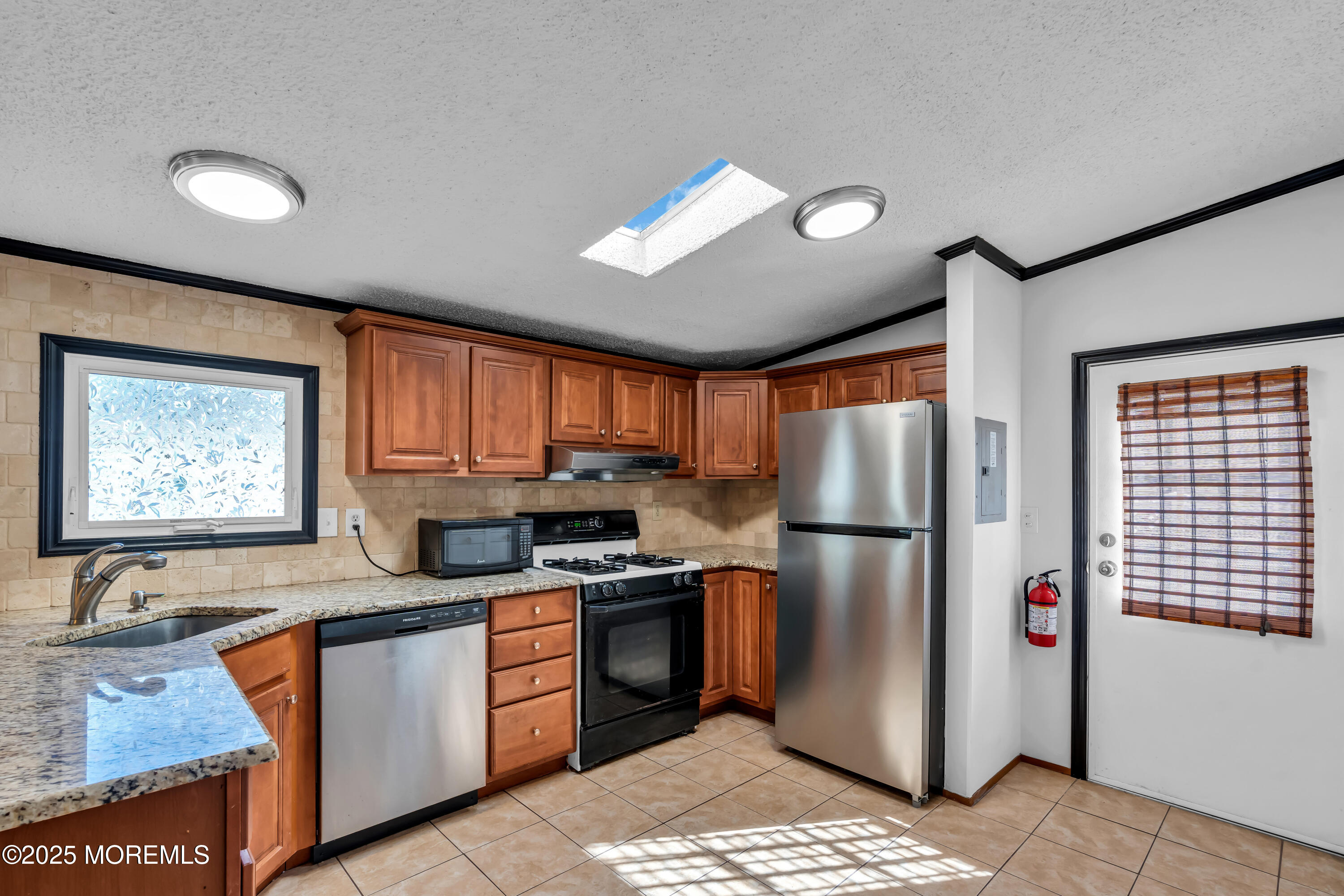 1820 Highway 35, Unit HOME SITE #26 Wall, NJ 07719 - Photo 15 of 35 a kitchen with granite countertop stainless steel appliances a refrigerator a sink a stove a chimney a sink and cabinets