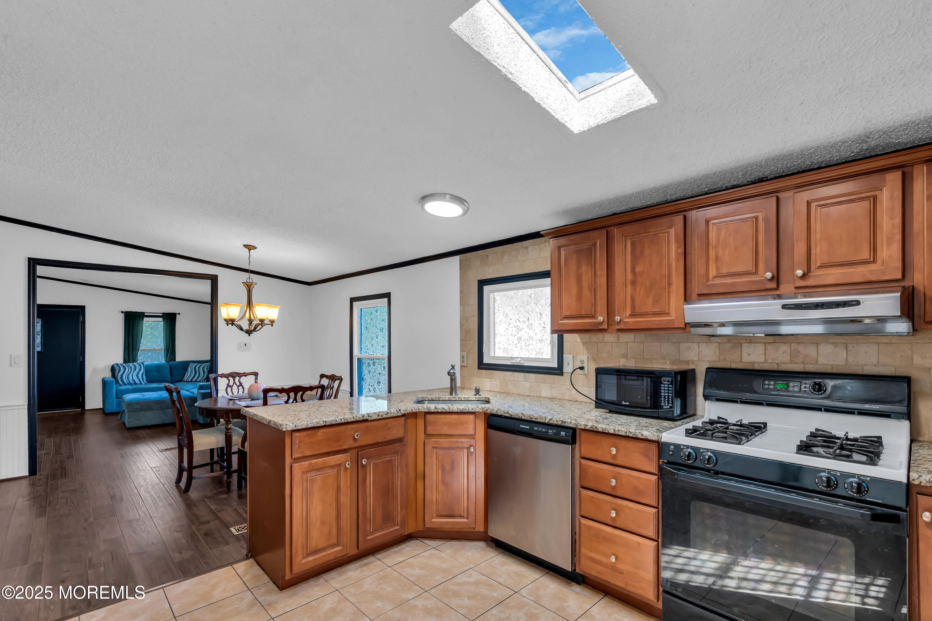 1820 Highway 35, Unit HOME SITE #26 Wall, NJ 07719 - Photo 16 of 35 a kitchen with stainless steel appliances granite countertop a stove a sink dishwasher and a microwave oven with wooden floor