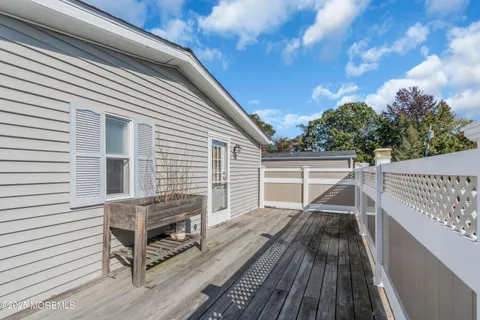 a view of a balcony with wooden floor and fence