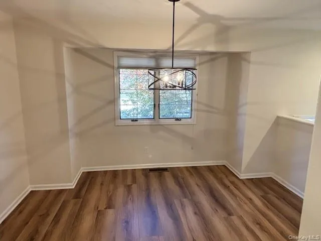 a view of wooden floor and chandelier in a room